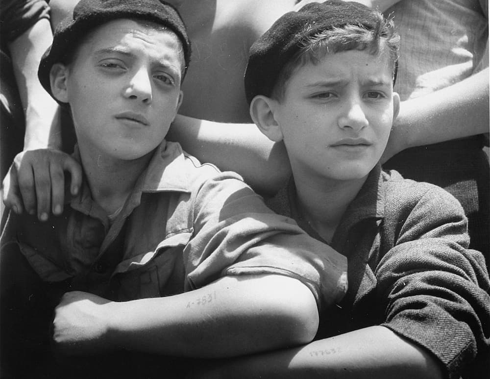 Two young child survivors on board the SS Mataroa display their tattooed arms. ——US Holocaust Memorial Museum, courtesy of Israel Government Press Office