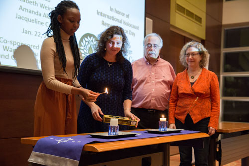 Candles were lit in memory of the Holocaust and of other genocides. Left to right: Amanda Akaliza '19; Lori Weintrob, professor and director of the Holocaust Center; Manny Saks, board member of the Wagner Chai Society; and Susan Lob.